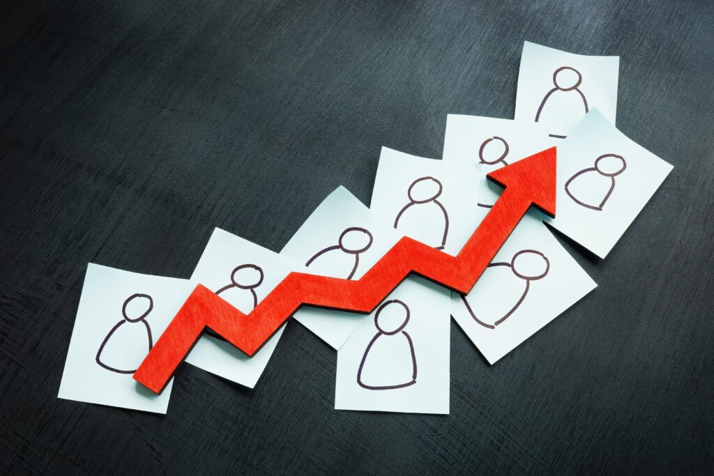 Pieces of paper with stick figures with an arrow rising, showing increase customer retention.