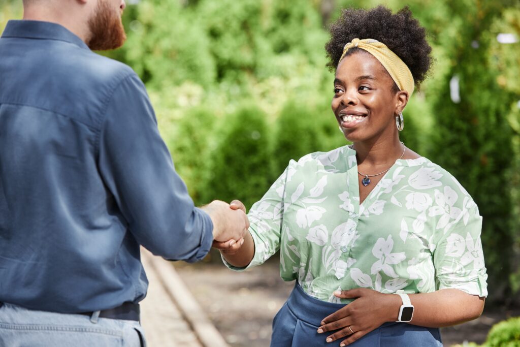 Sales professional connecting with a customer through a handshake.