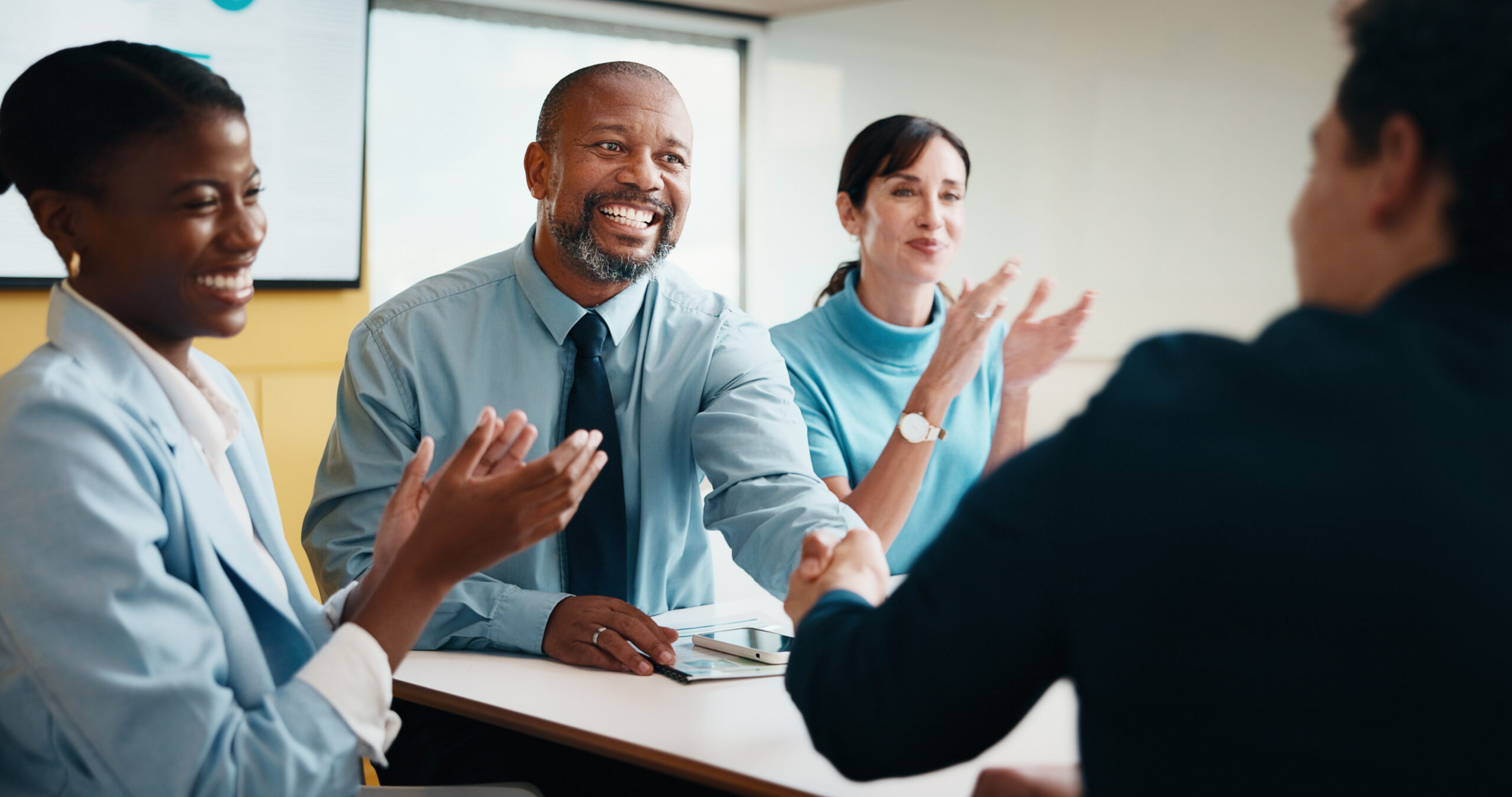 A male team congratulating an employee due to his career development.